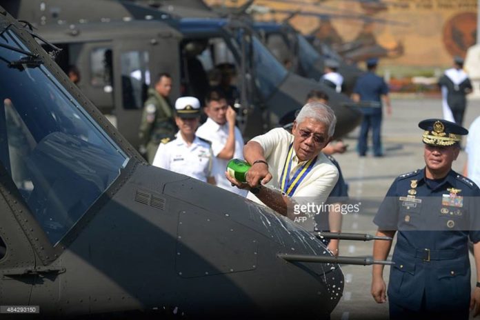 A Philippine Air Force chaplain blesses a newly-delivered Bell 412 helicopter with holy water during a christening ceremony in Manila on August 17, 2015