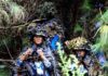 Kamuflase Marinir Tentara Pembebasan Rakyat Tiongkok Peleton PLAMC bersembunyi di balik pepohonan.