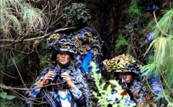 Peleton PLAMC bersembunyi di balik pepohonan.